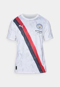 Bijela majica s kratkim rukavima koja sadrži crveno-crnu dijagonalnu prugu, grafički uzorak, logo Manchester Cityja i Puma brendiranje.