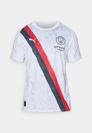 Valkoinen lyhythihainen pelipaita, jossa on punamusta viistostruktuuri, graafinen kuviotelu, Manchester Cityn logo ja Puma-brändäys.