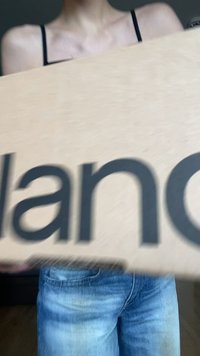 Kartonová krabice s nápisem "Balance" vytištěným tučně černými písmeny. Krabice je držena před osobou oblečenou v modrých džínách.