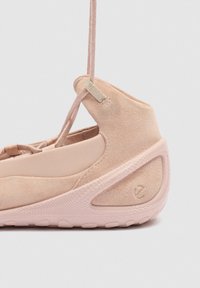 Heleroosa seemisnahast toss, millel on tekstuuriga tald, tõstetud konts ja paelasilmuse detail lihtsal taustal.