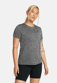 Harmaa lyhythihainen urheilupaita, jossa on heather-tekstuuri ja pieni logo rinnassa, yhdistettynä mustiin slim fit -shortseihin.