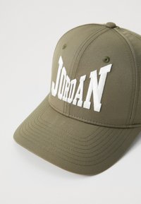 Căciulă de baseball de culoare verde măslin, cu literă albă brodată "JORDAN", design structurat și brâu curbat.