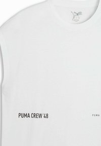 T-shirt en coton blanc avec col rond, manches courtes, et texte noir "PUMA CREW '48" sur le devant. Accents de marque subtils.