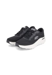 Czarne sportowe buty z siateczkową cholewką, z białą, amortyzującą podeszwą, z teksturowanym wykończeniem i wiązaniem. Logo wyeksponowane z boku.