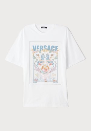 Valkoinen puuvillapaita, jossa on värikäs graafinen printti, johon on kuvattu merenneitoja, simpukoita ja "VERSACE"-logo sinisellä värillä keskellä. Lyhyet hihat.