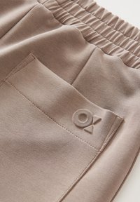 Bruine jersey stof broeken met een geraffineerde tailleband, zijzak met een reliëflogo en een soepele textuur.