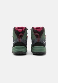High-top hiking boots in dark green and black with maroon accents, featuring a textured upper, sturdy sole, and reinforced eyelets.