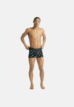 Zwarte boxershorts met witte driehoekige logo-patronen, elastische tailleband, aansluitend ontwerp, gedragen door een man met een atletisch figuur.