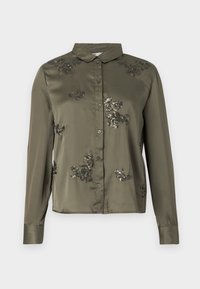 Satin olīvzaļš blūze ar apkakli, garām piedurknēm un priekšējiem pogām; satur melnas ziedu dekorācijas ar pērļu izšuvumiem.