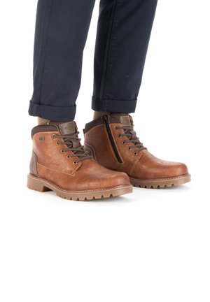 Bottines en cuir marron avec une finition texturée, design à cheville haute, devant à lacets, fermeture éclair sur le côté et semelle en caoutchouc épaisse.