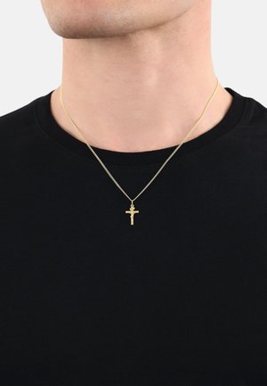 Collier en chaîne de couleur or avec un petit pendentif en crucifix. La chaîne a un design classique et une texture fine. Porté sur une chemise noire.