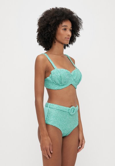 Top de bikini turquesa e brilhante com copas moldadas; parte de baixo alta coordenada apresenta um detalhe de cinto e acabamentos em tecido suave.
