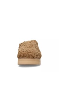 Scarpa slip-on marrone chiaro in tessuto morbido con parte superiore testurizzata e suola liscia chiara. Profilo basso, senza hardware o dettagli visibili.