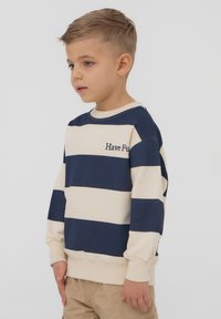 Felpa a righe blu navy e crema con ricamo "Have Fun", colletto a girocollo, maniche lunghe e polsini a costine.
