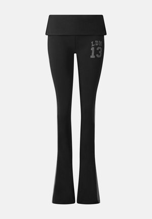 Μαύρο παντελόνι με φαρδιά ζιπ κιλότ και ψηλή μέση, με διπλωμένη μέση και το «LDN 13» τυπωμένο σε γκρι στην πάνω πλευρά του μηρού.