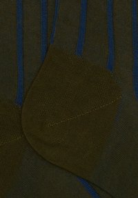 Calzini verde oliva con strisce blu scuro, dotati di tallone e punta rinforzati, e una finitura a maglia liscia e testurizzata.