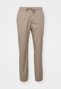 Beige kalhoty z bavlněné směsi s elastickým pasem a šňůrkou, s tapered nohavicemi a elastickými manžetami na kotnících.