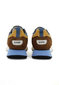 Sneakers z brązową zamszową cholewą, żółtymi i niebieskimi akcentami, szarym wykończeniem, białym logo na pięcie oraz niebieską podeszwą. Wzmocnione tylne wsparcie.