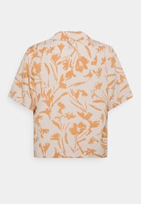 Chemise à manches courtes et coupe décontractée en tissu beige clair avec un motif floral orange et un col cranté. Le dos présente un design sans couture.