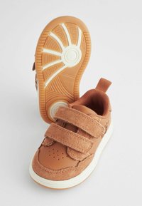 Brązowe trampki wykonane z leather i zamszu, z podwójnymi rzepami, zaokrąglonym noskiem oraz teksturowaną gumową podeszwą z okrągłym wzorem.