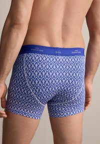 Blaue gemusterte Boxershorts mit einem charakteristischen Bund. Der Stoff zeigt ein Design von weißen Hummern auf einem blauen Hintergrund.