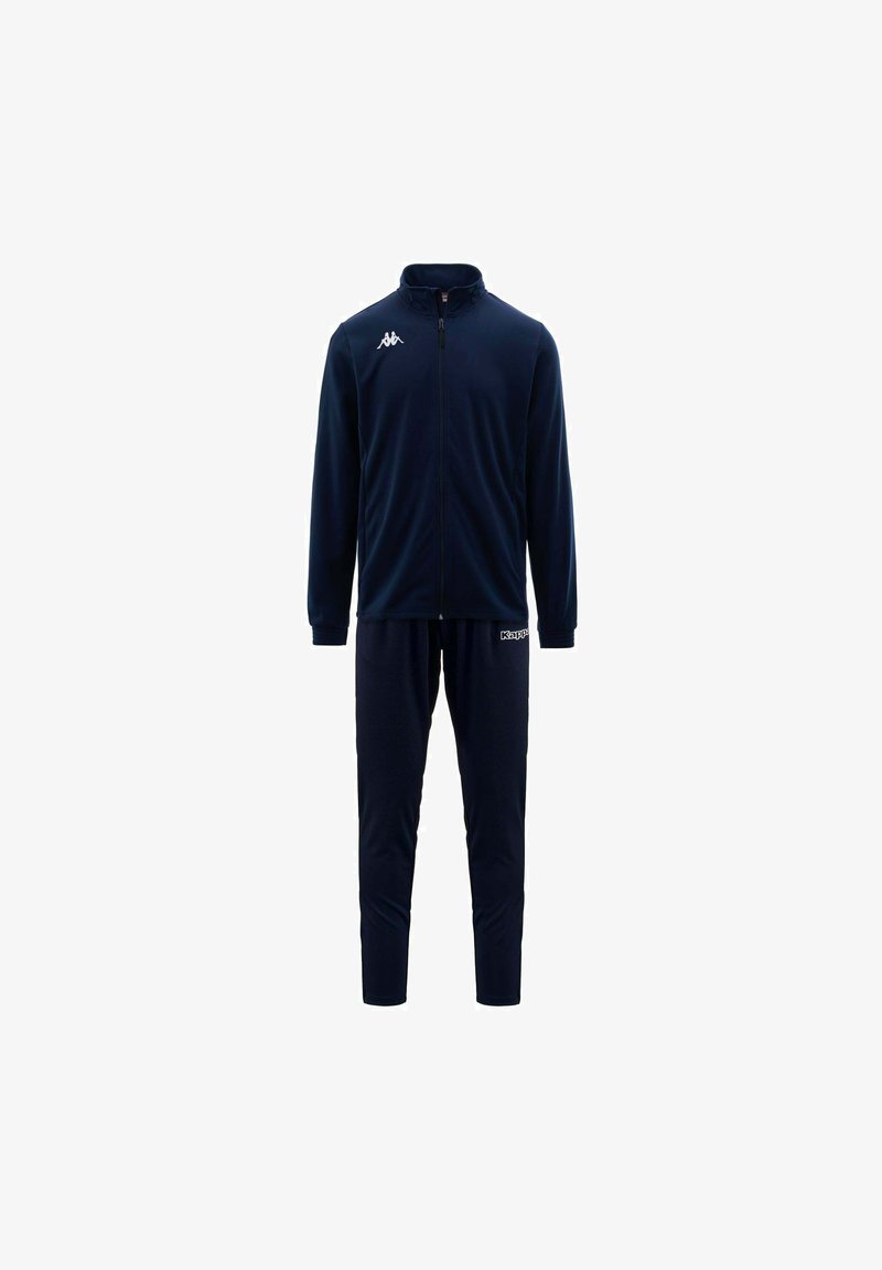 Survêtement marine en tissu lisse avec une veste zippée et un pantalon fuselé. Présente des accents de logo blanc sur la poitrine et la cuisse.