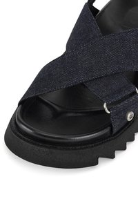 Sandale cu brâu încrucişat din denim închis, cu o talpă texturată neagră şi accente din metal argintiu. Dispune de un suport pentru picior căptuşit, rotunjit, pentru confort.