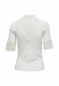 T-shirt blanc ajusté avec manches courtes en dentelle et encolure bordée de dentelle, comportant un motif triangulaire décoratif à l'arrière.