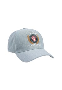 Czapka dżinsowa z zakrzywionym daszkiem, wyszywanym czerwonym logo tarczy, złotymi akcentami laurowymi oraz napisem "DIVERSE HERITAGE" w białym kolorze.