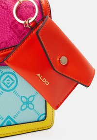 Colorful ALDO handbag featuring textured pink, blue with pattern, and yellow trim. Includes a red cardholder with a gold snap button.