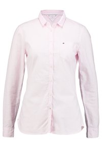 Camicia button-up rosa chiaro con righe verticali, maniche lunghe e una piccola tasca sul petto. Presenta un orlo arrotondato e bottoni bianchi.