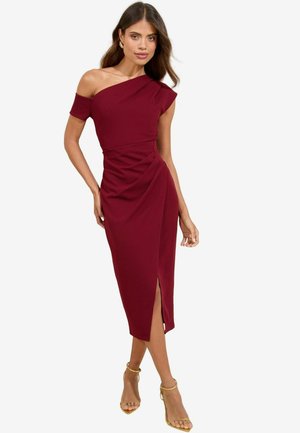 Burgundy off-the-shoulder dress with a fitted design, asymmetrical neckline, and draped detailing, featuring a side slit and smooth fabric.