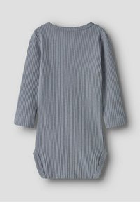 Body lungo grigio a costine con maniche lunghe e scollatura rotonda, dotato di aperture laterali per facilitare l'abbigliamento. Tessuto morbido e testurizzato.