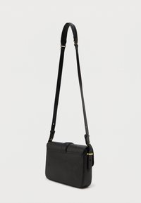 Fekete bőr keresztpántos táska téglalap alakú, lapos elülső résszel és állítható pánttal. Diszkrét gyémántmintázattal és arany színű kiegészítőkkel rendelkezik.