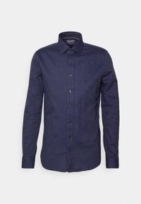Camicia a maniche lunghe blu navy in tessuto intrecciato, con chiusura a bottoni, colletto e logo discreto sul petto. Texture liscia.