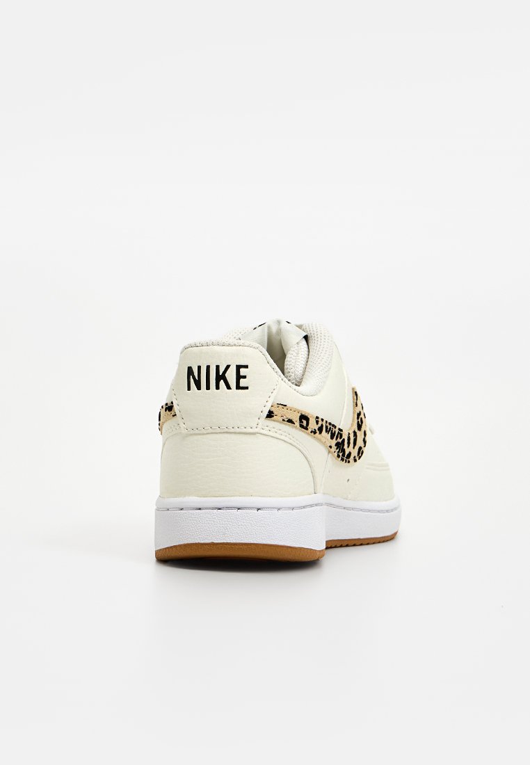 Weiße Leder-Nike-Sneaker mit einem Leopardenmuster-Akzent, ausgestattet mit einem gepolsterten Kragen und einer Gummisohle mit einer Gummiaußensohle.