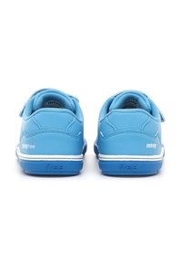 Zapatillas deportivas azules con un exterior sintético suave, correas de velcro, ribete blanco en la suela y suela de goma azul en contraste. Diseño redondeado.