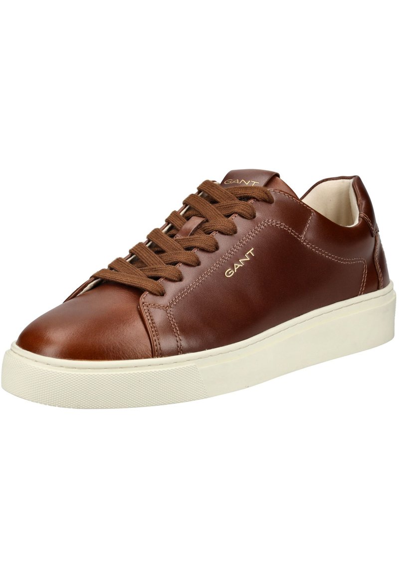 Zapatilla de cuero marrón con punta redonda, suela de goma blanca y cordones marrones. Presenta un logo sutil en el lateral y una textura suave.
