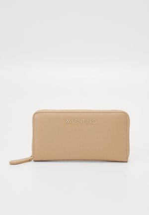 Portefeuille en cuir beige avec une texture lisse, fermeture éclair et logo "VALENTINO" en relief à l'avant. Forme rectangulaire avec bords arrondis.