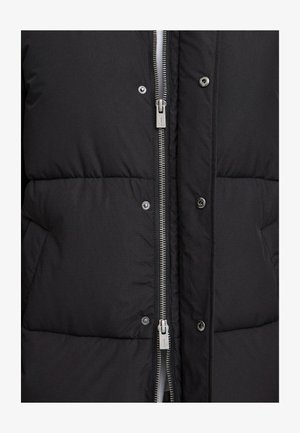 Schwarze Steppjacke mit einer gequilteten Textur, ausgestattet mit einem Frontreißverschluss und Druckknöpfen sowie grauen metallischen Hardware-Akzenten.