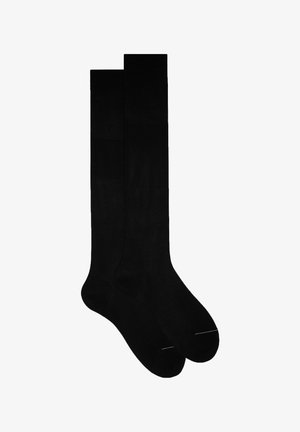 Calze nere al ginocchio realizzate in tessuto morbido. Presentano una punta rinforzata, un bordo superiore a costine e un design senza cuciture, privo di loghi o motivi visibili.