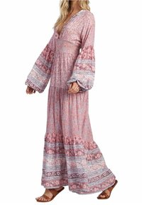 Maxiklänning i ljusrosa blommigt tyg med långa ärmar som vidgar sig, en V-ringning, texturerad överdel och en vågad nederkant med intrikata mönster.