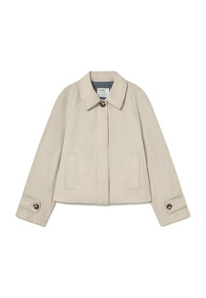 Chaqueta recortada beige con mangas largas, puños con botones, bolsillos frontales, un único botón visible y forro interior a cuadros en el cuello.