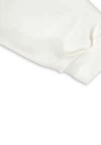 Der Bund des weißen Baumwollpullovers hat eine gerippte Textur und eine glatte Oberfläche, mit leichtem Raffungen an der Naht für einen taillierten Look.