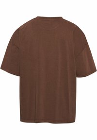 Brown oversized t-shirt made of soft cotton with a round neck and short sleeves, featuring a smooth texture and simple design.