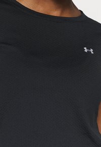 Svart sportlinne i texturerat tyg. Har rund halsringning och en liten grå logotyp på vänstra bröstområdet.