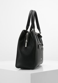 Sac à main en cuir texturé noir avec fermeture éclair, poignées doubles et accent en métal argenté. Présente une forme structurée et des coutures visibles.