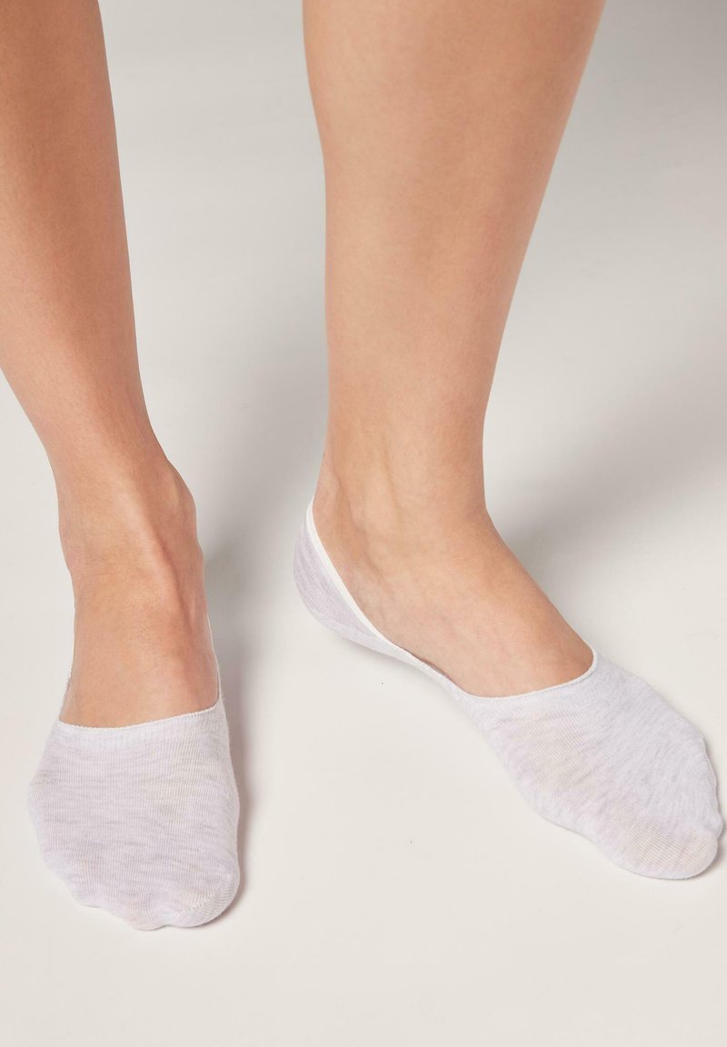 Weiße Knöchelsocken aus weichem, leichtem Stoff; tief geschnittenes Design mit einer glatten Oberfläche und minimaler Naht an den Kanten.