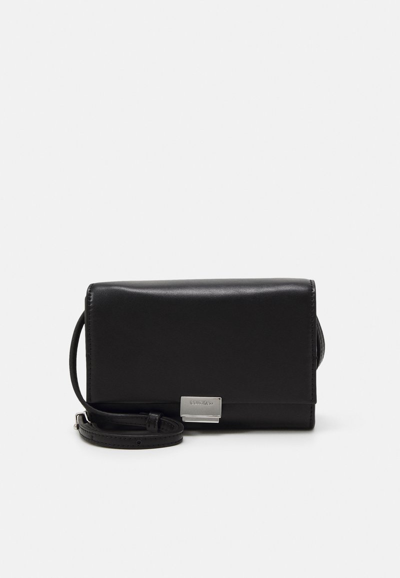 Čierna kožená crossbody taška s obdĺžnikovým tvarom, hladkým povrchom, preklápacím uzáverom a striebornými prvkami. Obsahuje nastaviteľný popruh.