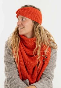 Oranje gebreide sjaal om de nek met een bijpassend hoofdband. De textuurstof heeft een gedraaide design en houten kralenaccenten.